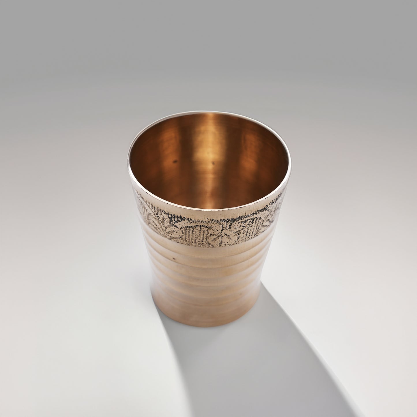 उभरे हुए डिज़ाइन वाला पीतल का छोटा पूजा गिलास